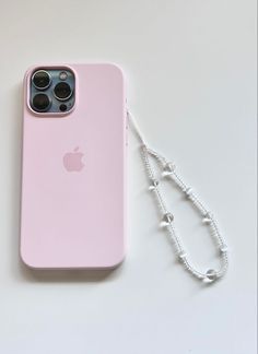 an iphone case is laying next to a lanyard on a white surface with a keychain