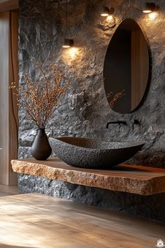 a bathroom with stone walls and wood flooring, two vessel sinks on the counter