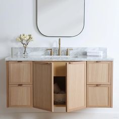 a bathroom vanity with marble top and wooden cabinets