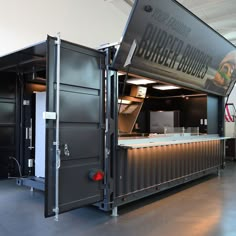 an open shipping container with food on the counter and stairs leading up to it's door