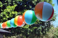 several colorful beach balls hanging from a line