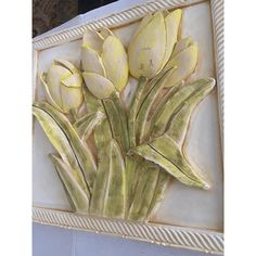 a painting of yellow tulips in a white frame