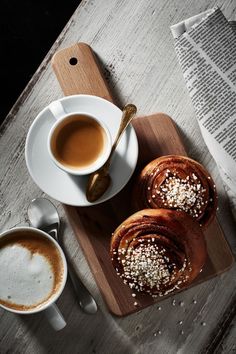 coffee and pastries on a wooden cutting board