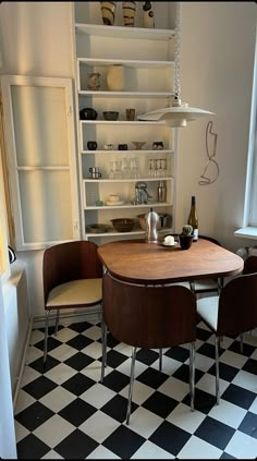 a table and chairs in a room with black and white checkered tile flooring