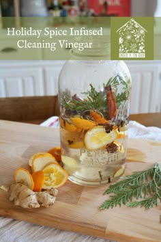 a wooden cutting board topped with a jar filled with lemons and herbs