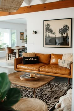 a living room filled with furniture and a large painting on the wall above it's coffee table