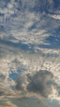 an airplane is flying in the sky with clouds