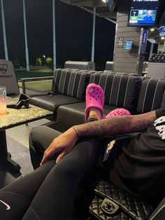 a man sitting on top of a couch next to a table with a drink in it