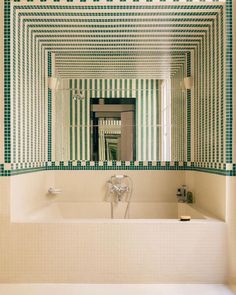 a white bath tub sitting under a bathroom mirror