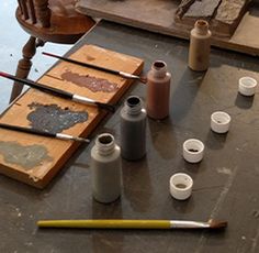 the table is covered with different types of crafting supplies, including paint and brushes