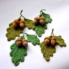 four crocheted acorns with leaves and acorns hanging from them