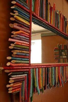 a mirror that has some pencils on it and is made out of bookshelves