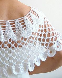 the back of a woman's white top with crocheted lace on it