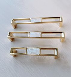 three pieces of gold metal sitting on top of a table