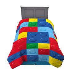 a bed with a red, yellow and blue lego comforter set on top of it