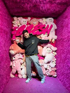 a man standing in front of a pile of stuffed animals