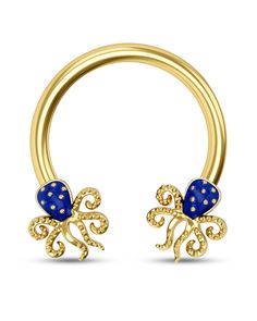 an open gold nose ring with blue stones on the outside and two small bows in the middle