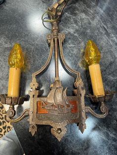 two yellow candles sitting on top of a chandelier with leopard print fabric around it