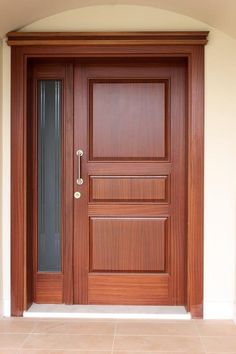 a wooden door in front of a white wall