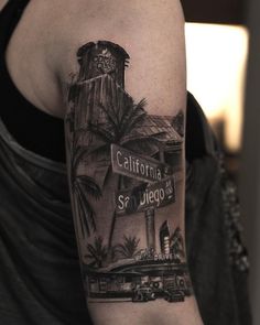 a woman with a tattoo on her arm has a street sign and palm trees in the background