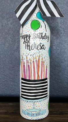 a birthday bottle with candles on it and a ribbon around the top that says happy birthday theresa