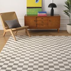 a living room with a checkered rug and wooden furniture in front of a painting on the wall