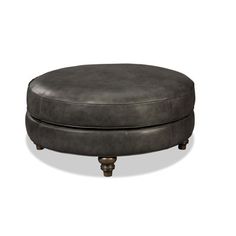 a round ottoman sitting on top of a wooden table