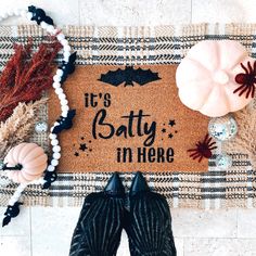 someone is standing in front of a door mat that says it's batty in here