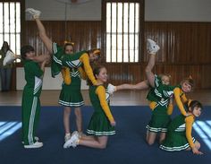 a group of girls in green and yellow cheer outfits