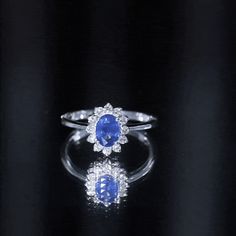 a blue and white ring sitting on top of a black table next to a mirror