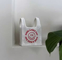 a white plastic bag with a smiley face on it hanging from the side of a wall