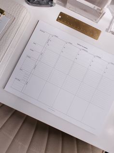 a desk with a calendar, pen and glasses on it