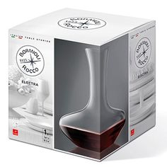 a box with a wine glass inside of it on a white surface and an image of a kitchen utensil in the background