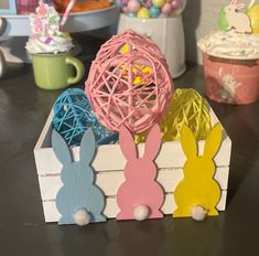 some bunny ears are sitting in a box on the table next to cupcakes