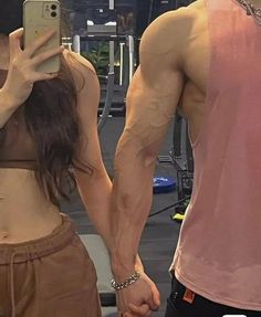 a man and woman taking a selfie in the gym