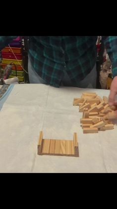 a person is making wooden pieces on a table