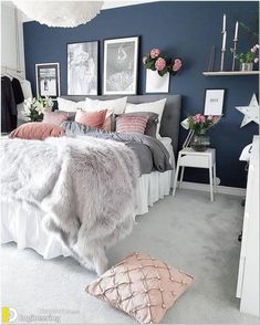 a bedroom with blue walls and white carpeted flooring is decorated in pink and grey