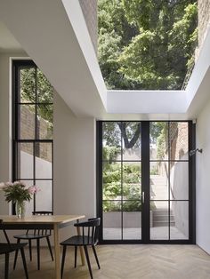 an image of a living room and dining area with glass doors that open up to the outside