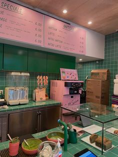 there is a green tiled counter top in the kitchen with boxes on it and other food items