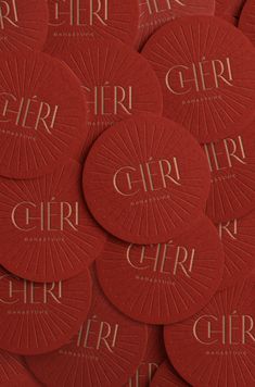 red circular coasters with the word girl printed on them in gold foiled lettering