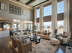 a living room filled with furniture and large windows