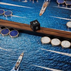 a close up of a board game with dices and boats in the water behind it