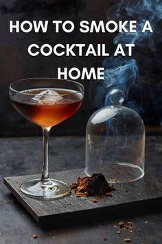 a drink sitting on top of a wooden cutting board next to a decanter