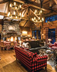 a living room filled with furniture and a fire place next to a stone fireplace in a log cabin