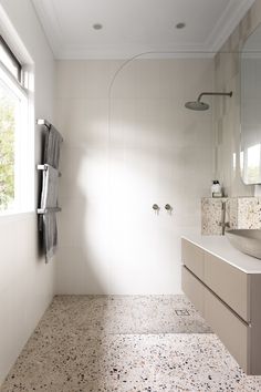 a bathroom with a sink, mirror and shower head in the middle of the room