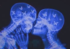 two skeletons kissing each other with butterflies on their heads in front of a black background