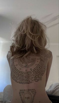 the back of a woman's body with tattoos on her upper and lower back