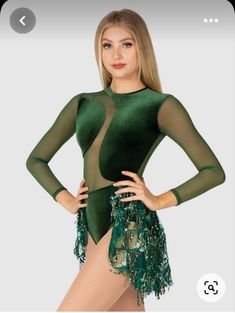 a woman in a green leotard posing for the camera with her hands on her hips