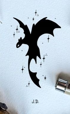 a drawing of a black dragon with stars on it's back and the letter j d