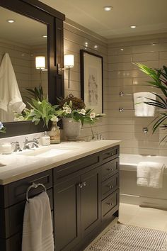 a bathroom with two sinks and a bathtub next to a large mirror on the wall